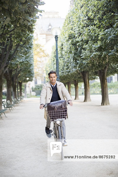 Businessman riding bicycle in park  Paris  France