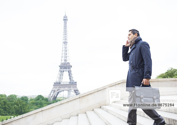 Geschäftsleute am Handy auf der Treppe beim Eiffelturm,  Paris,  Frankreich