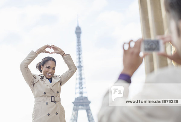 Mann fotografiert Freundin vor dem Eiffelturm,  Paris,  Frankreich