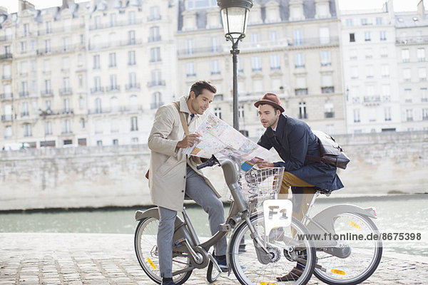 Männer auf Fahrrädern lesen Karte entlang der Seine  Paris  Frankreich