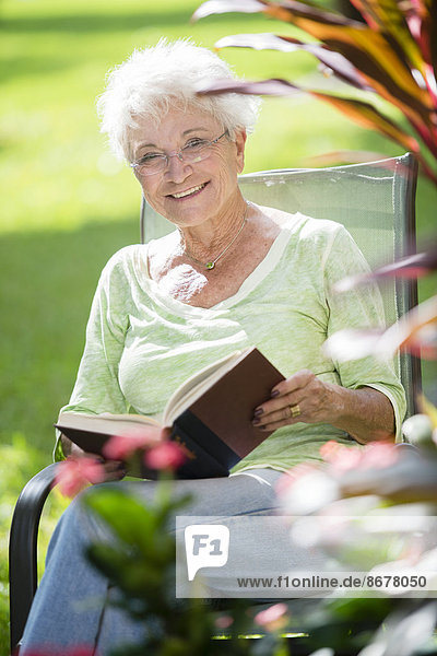Außenaufnahme Senior Senioren Europäer Frau Buch Taschenbuch freie Natur vorlesen
