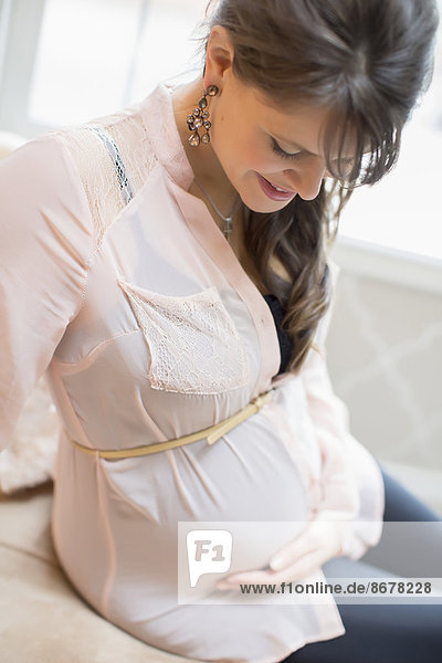 Caucasian woman holding pregnant belly