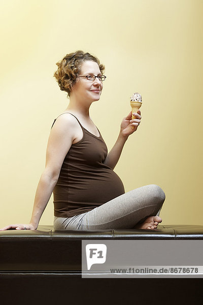 kegelförmig  Kegel  Europäer  Frau  Eis  Schwangerschaft  essen  essend  isst  Sahne
