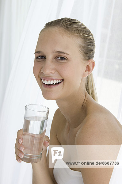 Ein Spa-Behandlungszentrum. Eine junge Frau  die ein Glas Wasser trinkt.