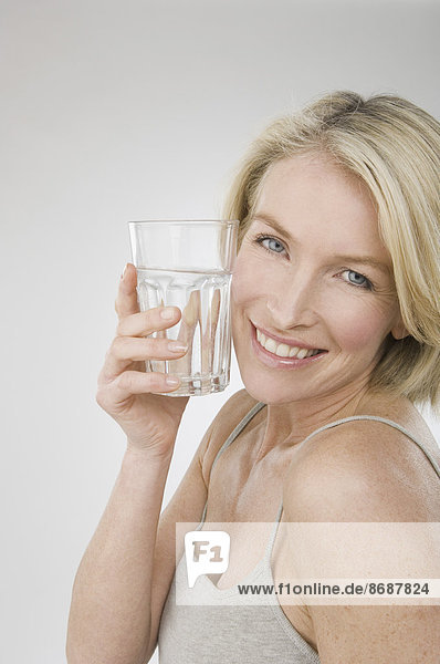 Eine Frau hält ein Glas Wasser.