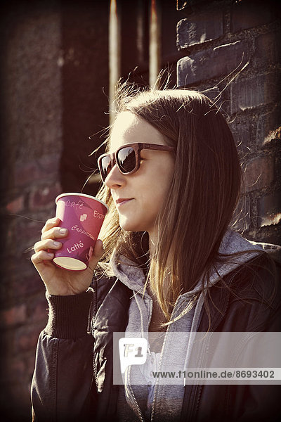 Young woman with sunglasses and coffee to go