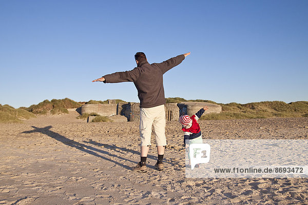 Denmark  Blavand  little girl and her father playing on the beach