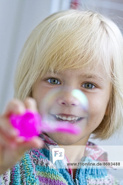 Porträt des lächelnden Mädchens mit Seifenblase