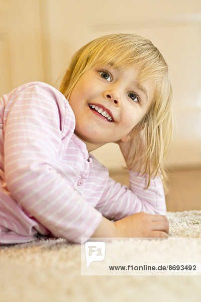 Porträt eines lächelnden kleinen Mädchens mit Kopf in der Hand