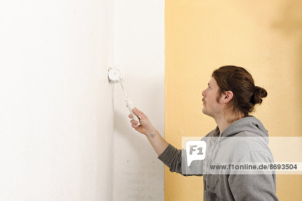 Junger Mann malt Wand