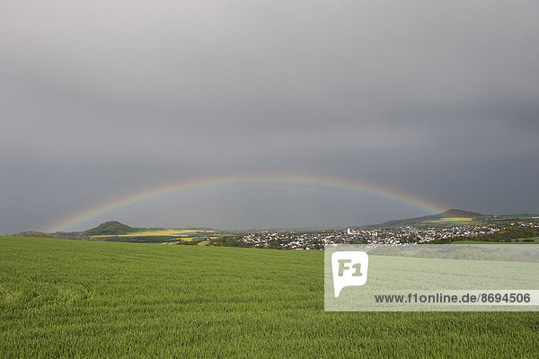 Deutschland  Rheinland-Pfalz  Vulkaneifel  Ochtendung  Regenbogen am dunkelgrauen Himmel