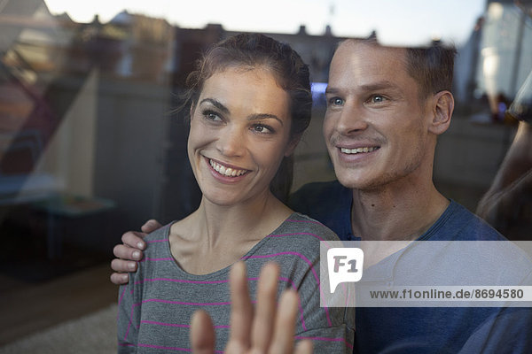 Smiling couple behind window