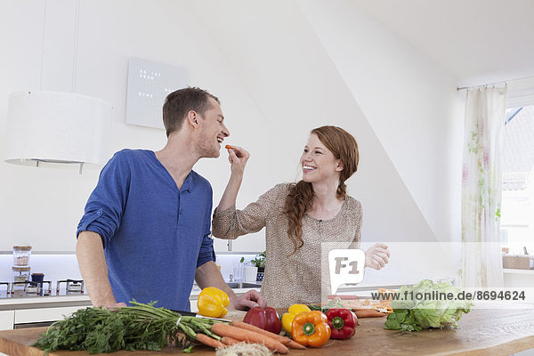 Young couple preparing food in kitchen
