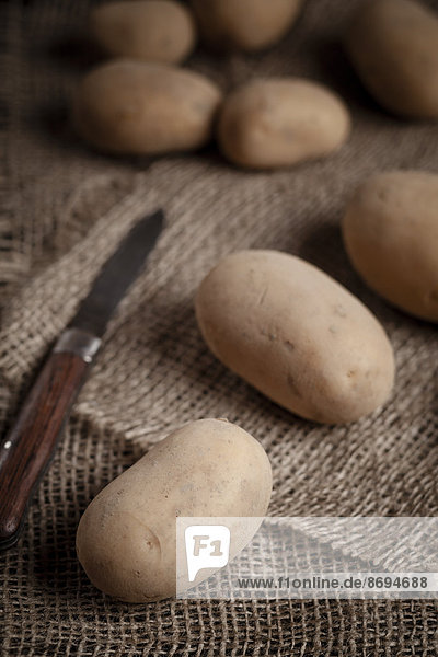 Kartoffeln und Messer auf Jute  Nahaufnahme