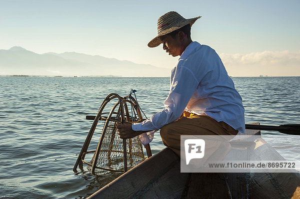 Fishermen with a traditional basket  canoe  Inle Lake  Shan State  Myanmar