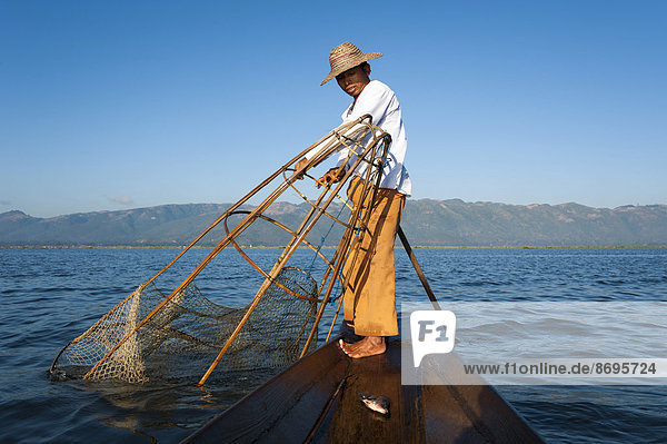 Fishermen with a traditional basket  caught fish in the canoe  Inle Lake  Shan State  Myanmar
