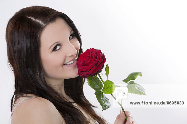 Lächelnde junge Frau mit roter Rose