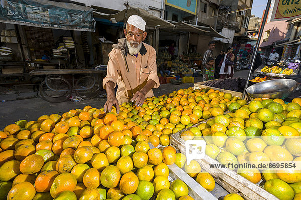 Ein Händer bietet Orangen auf dem Markt an  Ahmedabad  Gujarat  Indien