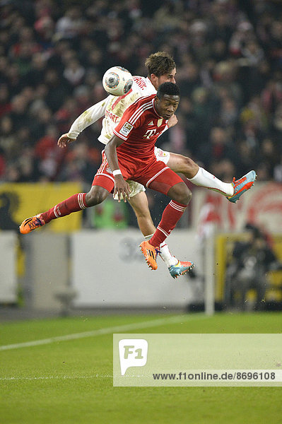 Two players jumping to head a ball  Martin Harnik  VfB Stuttgart  at the back  vs David Alaba  FC Bavaria Munich  at the front  Mercedes-Benz Arena  Stuttgart  Baden-Württemberg  Germany