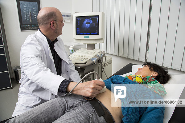 Arztpraxis  Internist untersucht eine Patientin mit einem Ultraschallgerät  Sonographie  Deutschland
