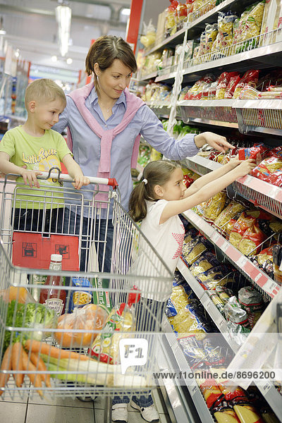Mother and children shopping for food  woman 35 years  girl 7 years and a boy 5 years