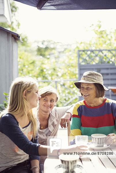 Drei Generationen Weibchen beim Kaffee im Hof