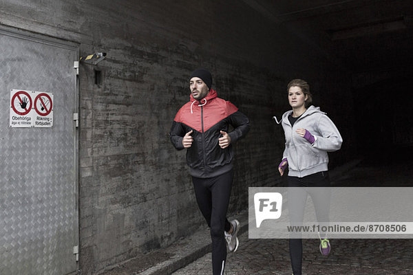 Sportliches Paar beim Laufen im Tunnel