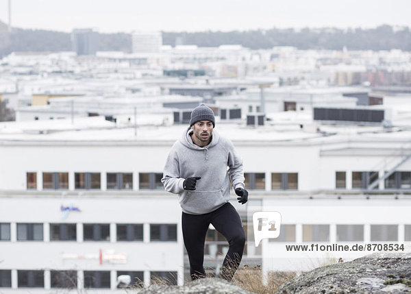 Mann joggt gegen Gebäude
