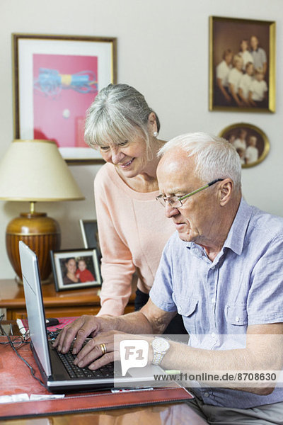 Senior Paar mit Laptop zu Hause