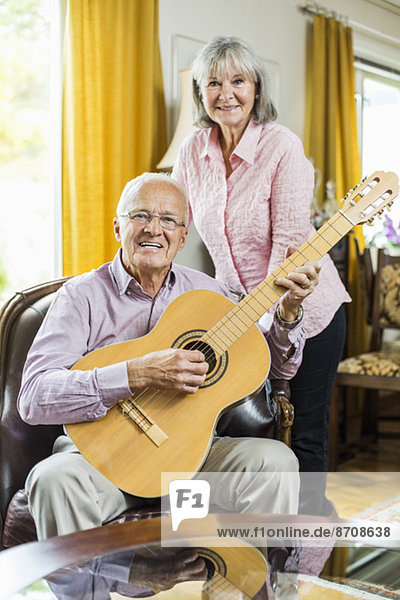Porträt eines älteren Paares mit Gitarre zu Hause