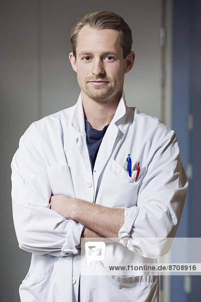 Portrait of confident male doctor with arms crossed in hospital
