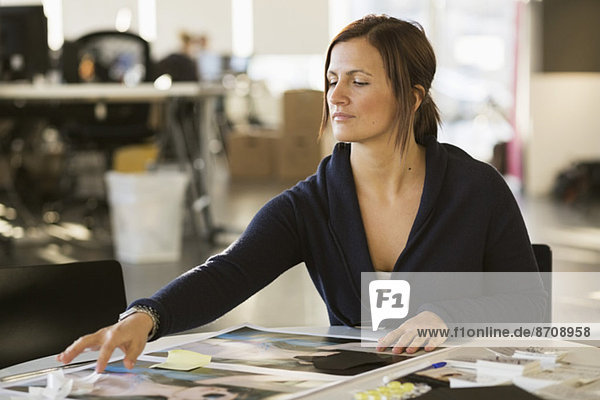 Young businesswoman working on photographs in office