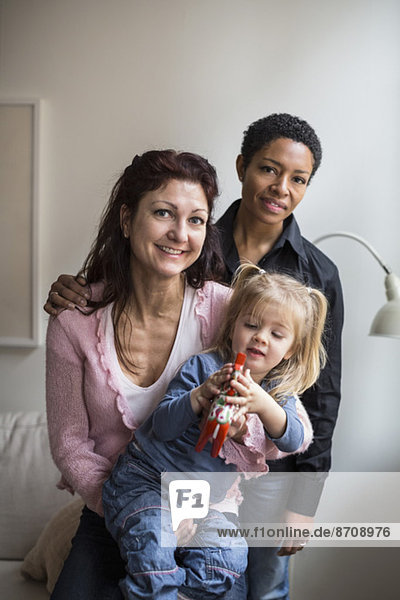 Porträt eines lesbischen Paares mit Mädchen zu Hause