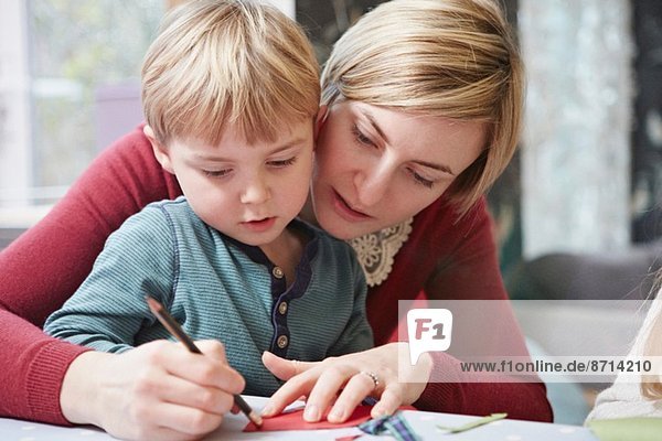 Mutter und Sohn zeichnen am Küchentisch