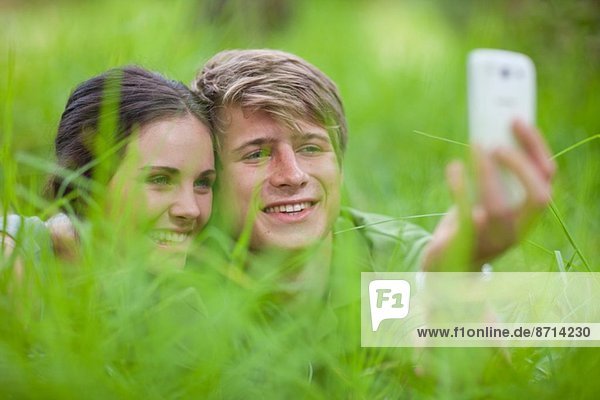 Junges Paar selbst fotografiert auf Gras