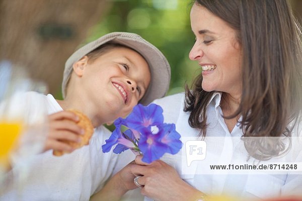 Boy giving flowers to mother