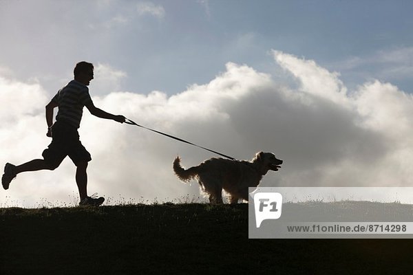 Man running with dog on lead