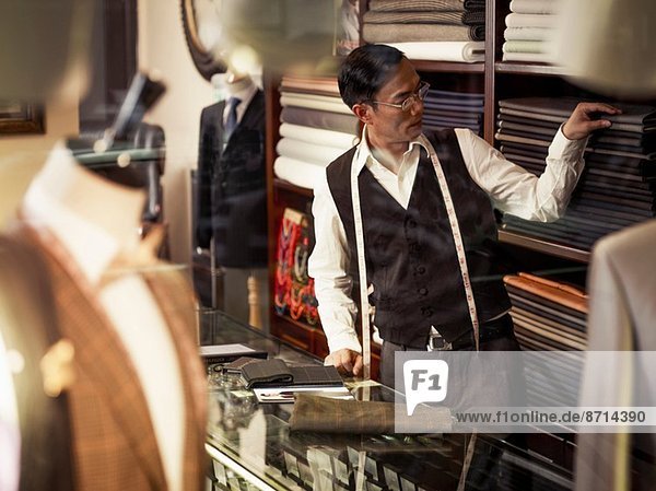 Tailor choosing fabric in traditional tailors shop