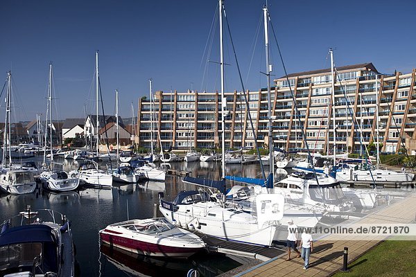 People passing yachts and power boats moored at Port Solent marina  near Portsmouth  South Coast of England  UK