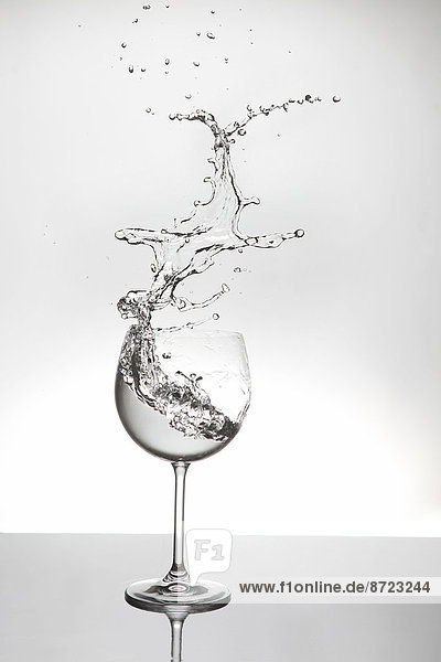 Wasser spritzt aus einem Weinglas
