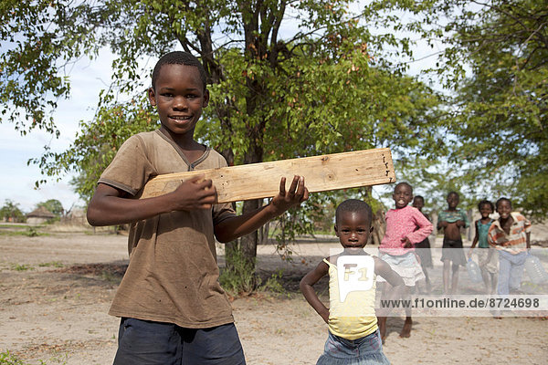 Children with a self-made toy guitar made of wood  Okavango Delta  Botswana
