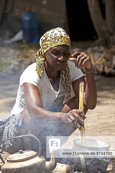 Kavango-Frau bei der Zubereitung des traditionellen Maismehl-Gerichts Ugali am Lagerfeuer  Okavango-Delta  Botswana