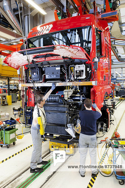 Employees assembling the chassis  engine and gearbox to the cab  at MAN Truck and Bus AG  Munich  Upper Bavaria  Bavaria  Germany