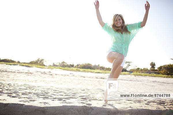Young Woman Smiling and Jumping on Beach  Palm Beach Gardens  Palm Beach County  Florida  USA