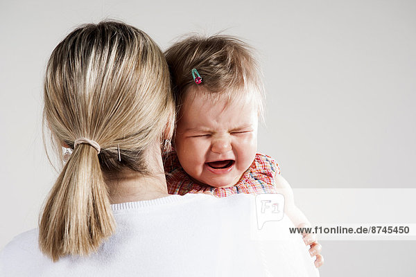 Studioaufnahme  weinen  über  halten  Ansicht  Mädchen  Mutter - Mensch  Baby
