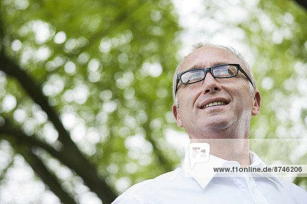 Close-up portrait of mature man wearing horn-rimmed eyeglasses in park  Mannheim  Germany