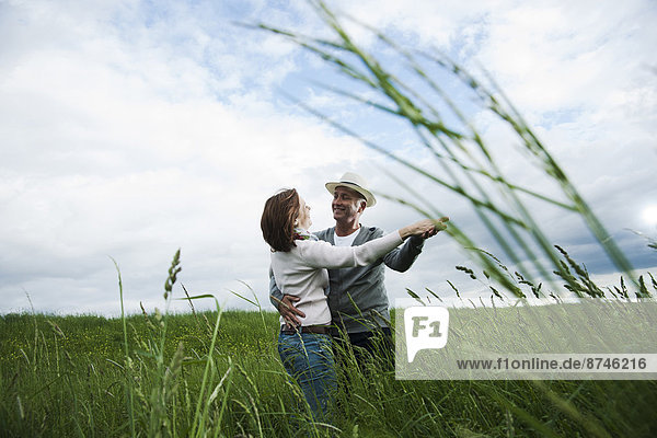 Mature couple dancing in field of grass  Germany