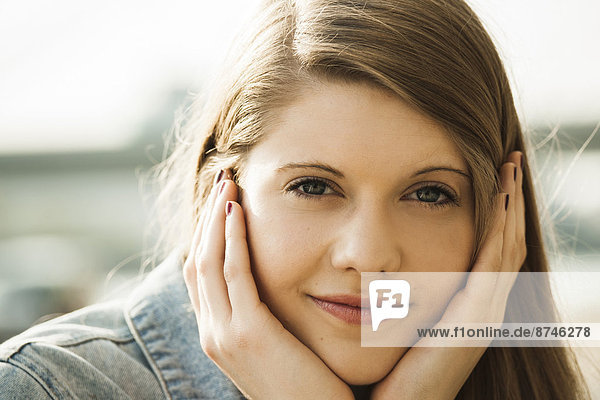 Close-up portrait of young woman outdoors  smiling at camera