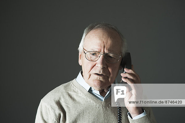 Elderly Man Talking on Phone in Studio