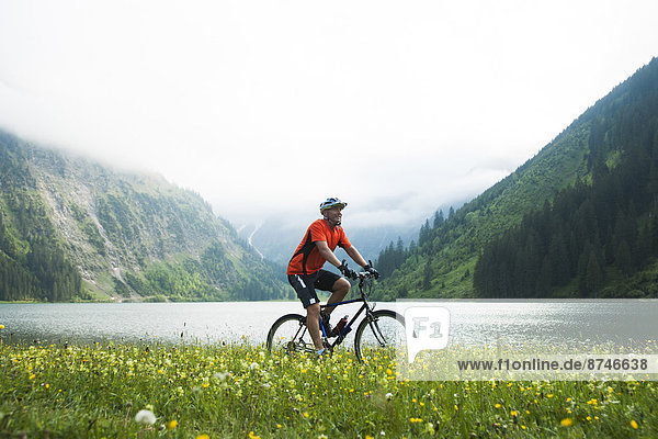 Mature Man Riding Mountain Bike by Vilsalpsee  Tannheim Valley  Tyrol  Austria